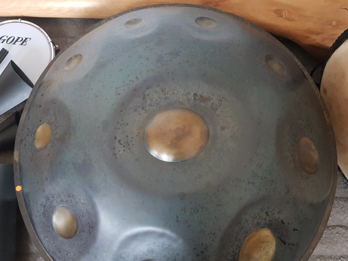 Handpan entouré d'un didgeridoo en bois et de percussions